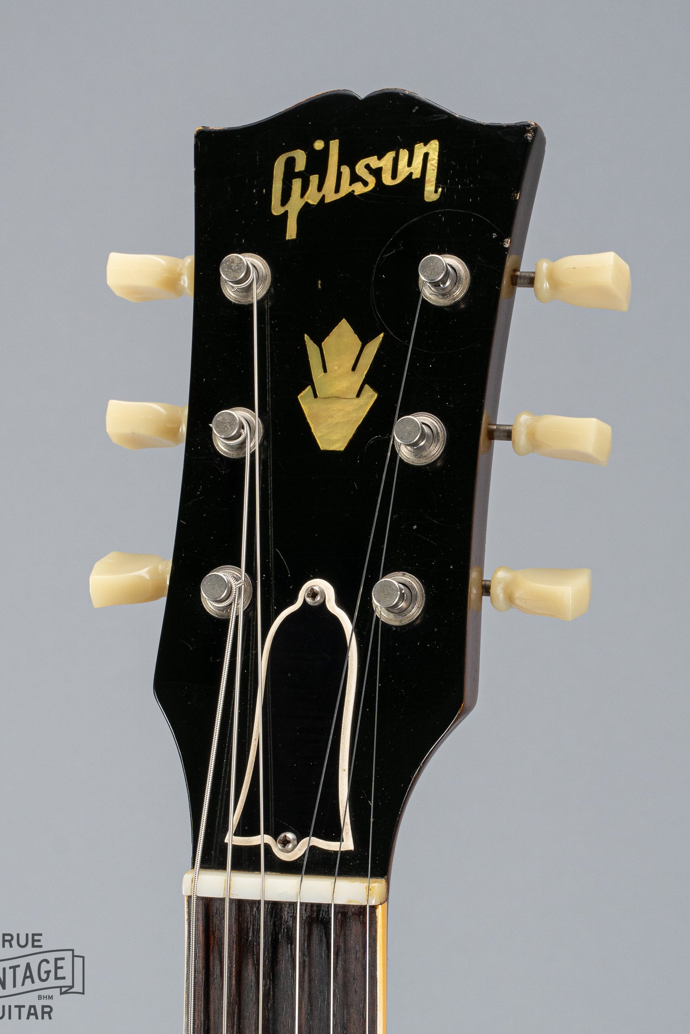 This image shows the front of the headstock of a 1959 Gibson ES-335 with pearl Gibson inlay