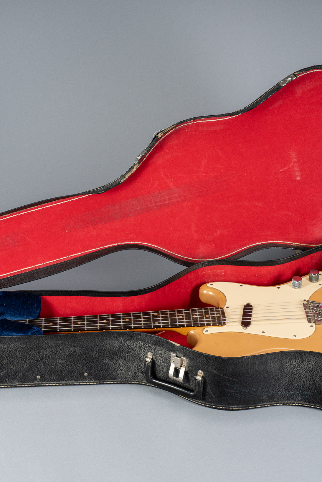 Front of 1960 Fender Musicmaster desert sand guitar body in hardshell case