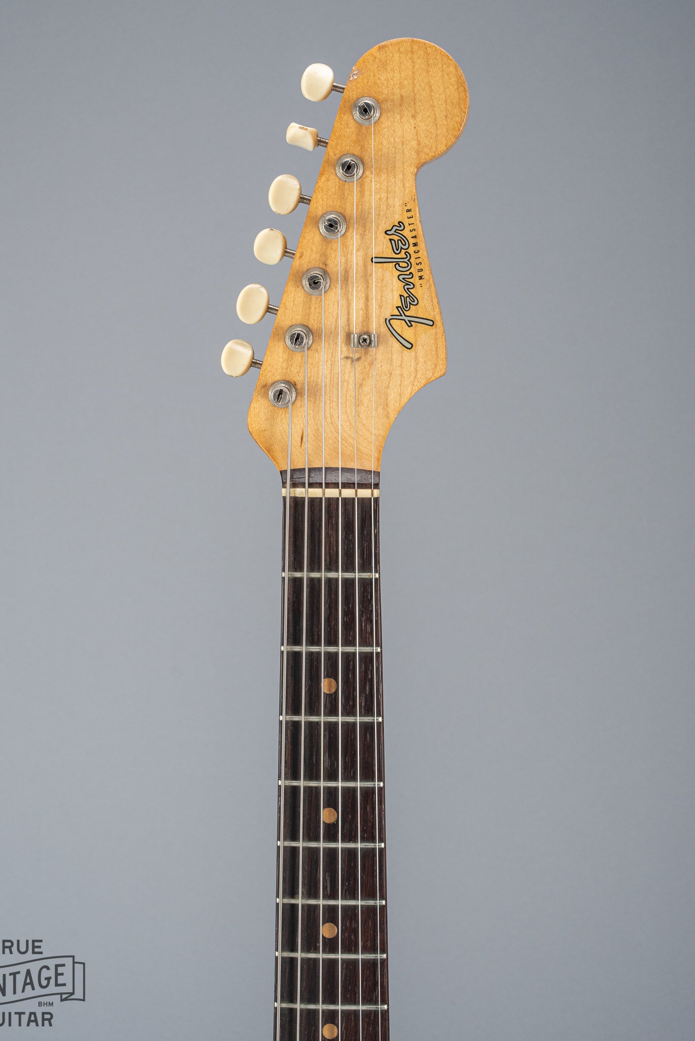 Front of 1960 Fender Musicmaster desert sand guitar neck and headstock fretboard tuners fender logo