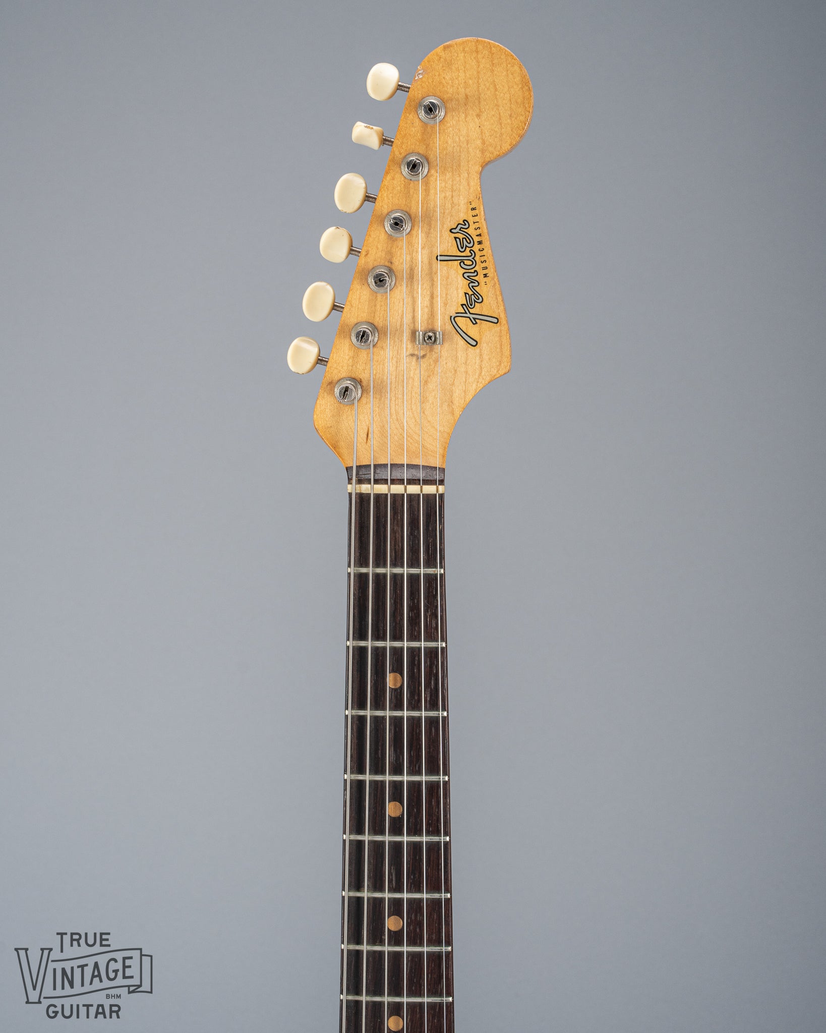 Front of 1960 Fender Musicmaster desert sand guitar neck and headstock fretboard tuners fender logo
