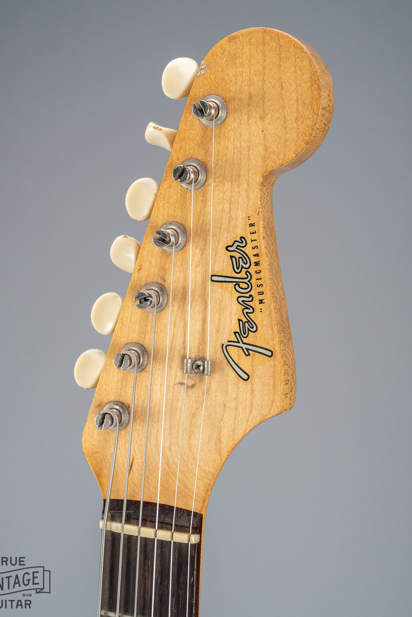 Front of 1960 Fender Musicmaster desert sand guitar headstock logo tuner buttons nut