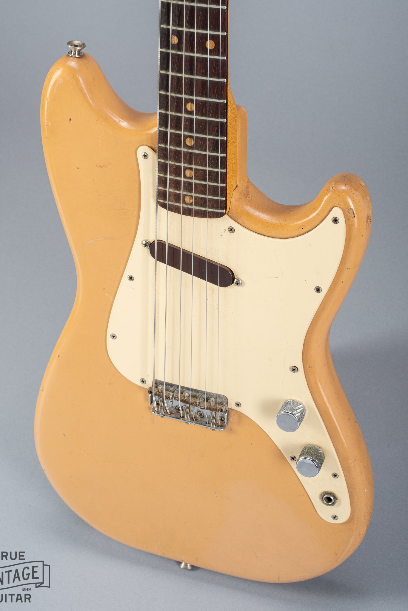 Front of 1960 Fender Musicmaster desert sand guitar body volume tone controls single coil pickups fretboard