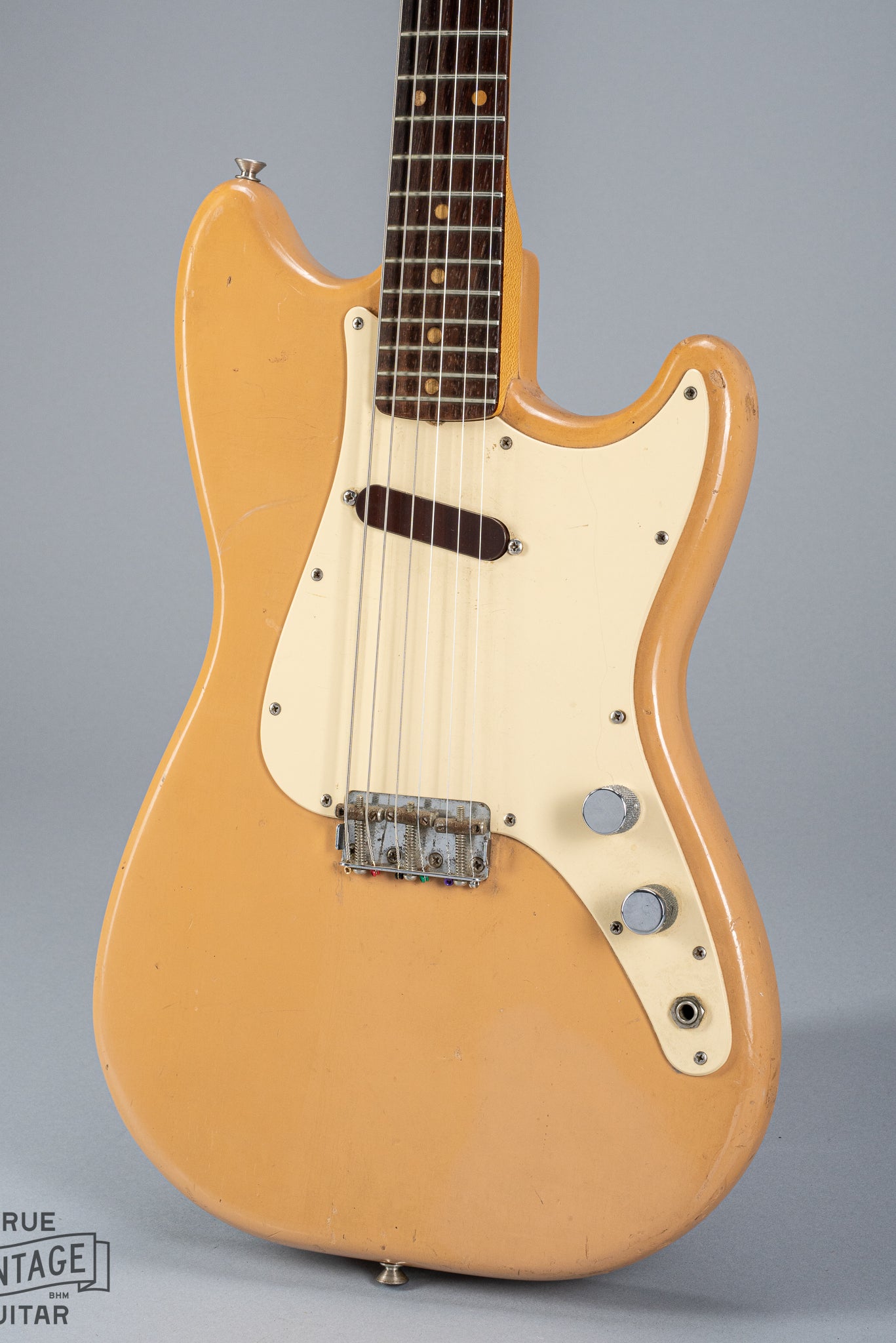 Front of 1960 Fender Musicmaster desert sand guitar body volume tone controls single coil pickups fretboard