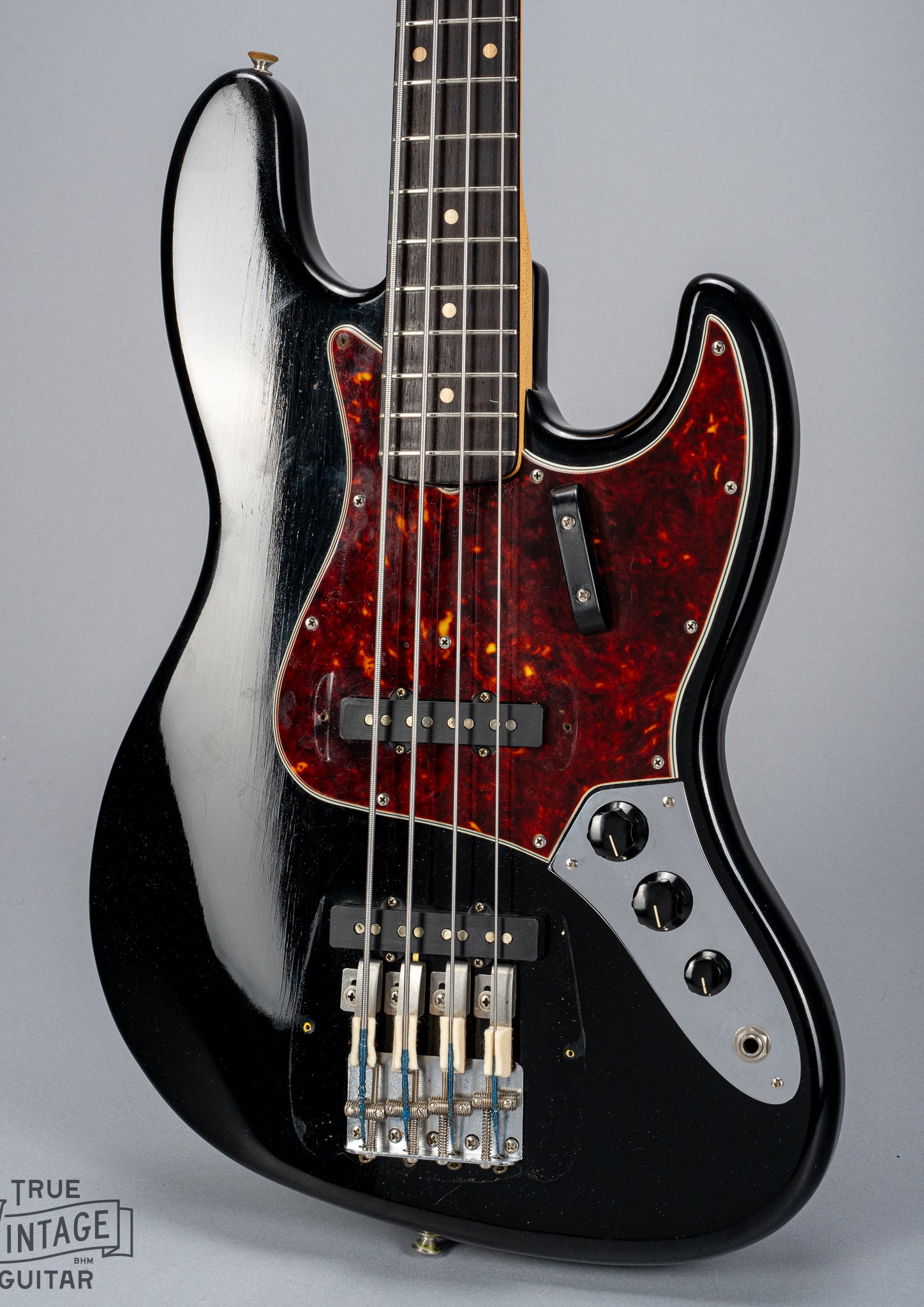 Front of 1962 Fender Jazz Bass custom color black custom color guitar tortoise shell pick guard no bridge and pickup cover finish checking