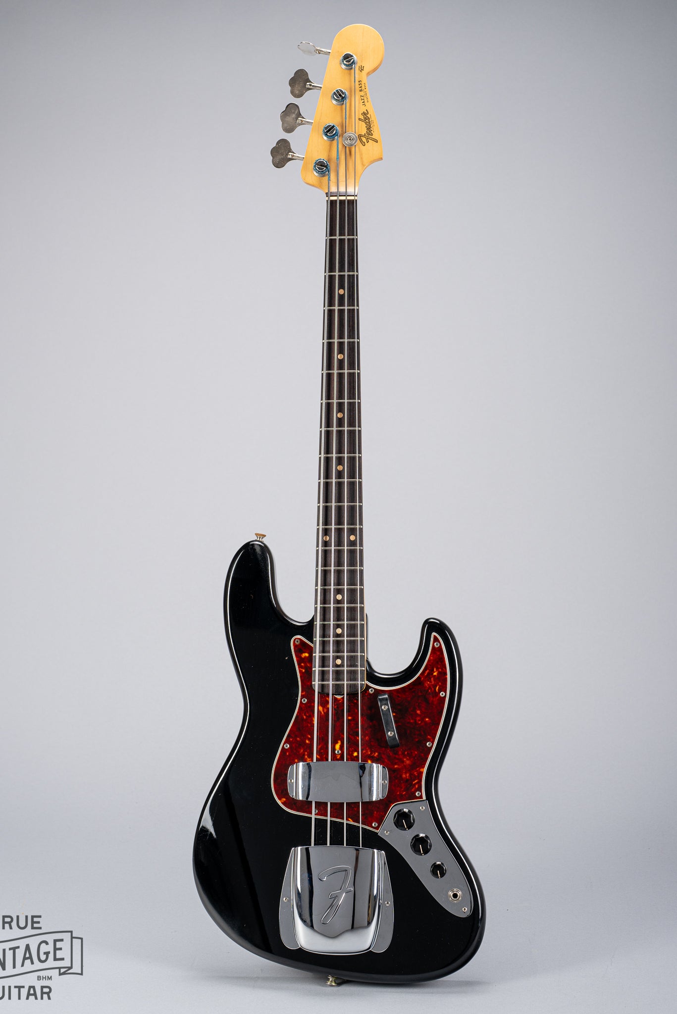 Front of 1962 Fender Jazz Bass custom color black custom color guitar tortoise shell pick guard fretboard headstock tuners