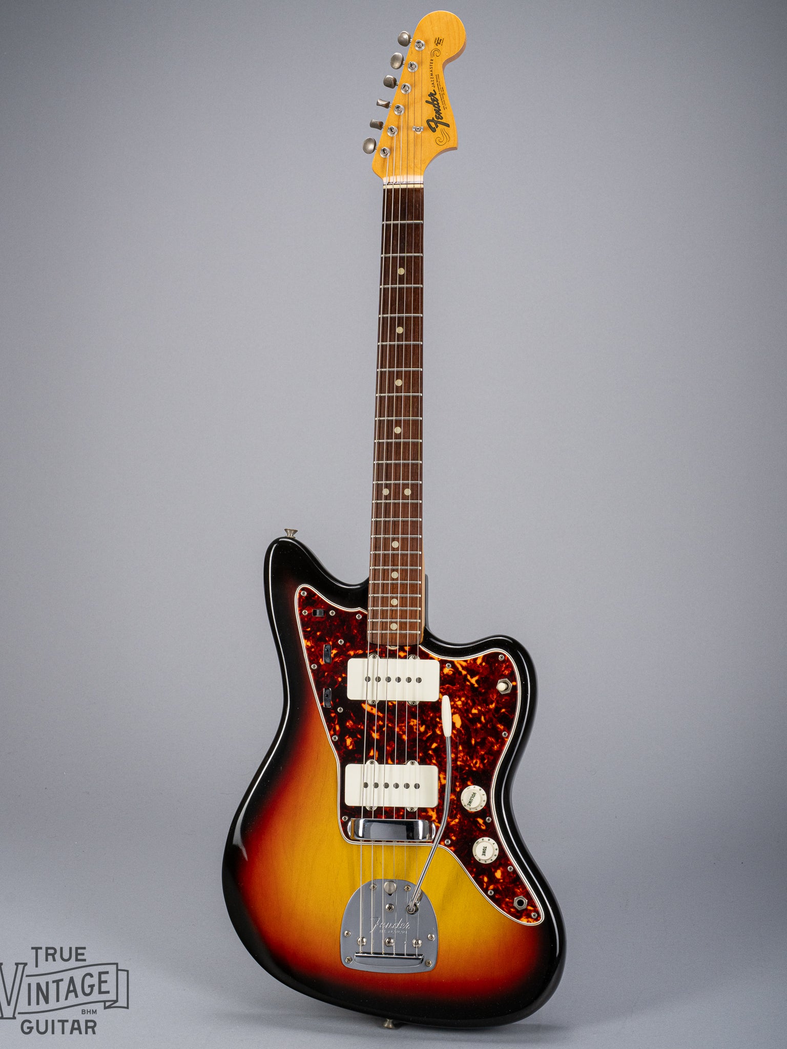 Front of 1965 Fender Jazzmaster sunburst guitar body tortoise shell pickguard pickups bridge tremolo neck and headstock
