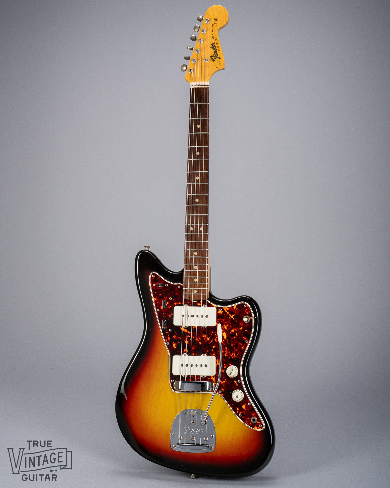 Front of 1965 Fender Jazzmaster sunburst guitar body tortoise shell pickguard pickups bridge tremolo neck and headstock