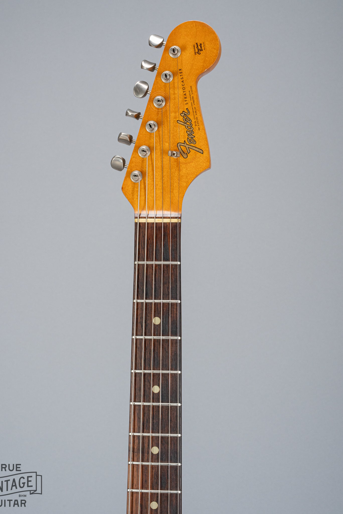 front of 1965 Fender Stratocaster Sunburst guitar neck headstock and fretboard Fender logo nut tuning machines