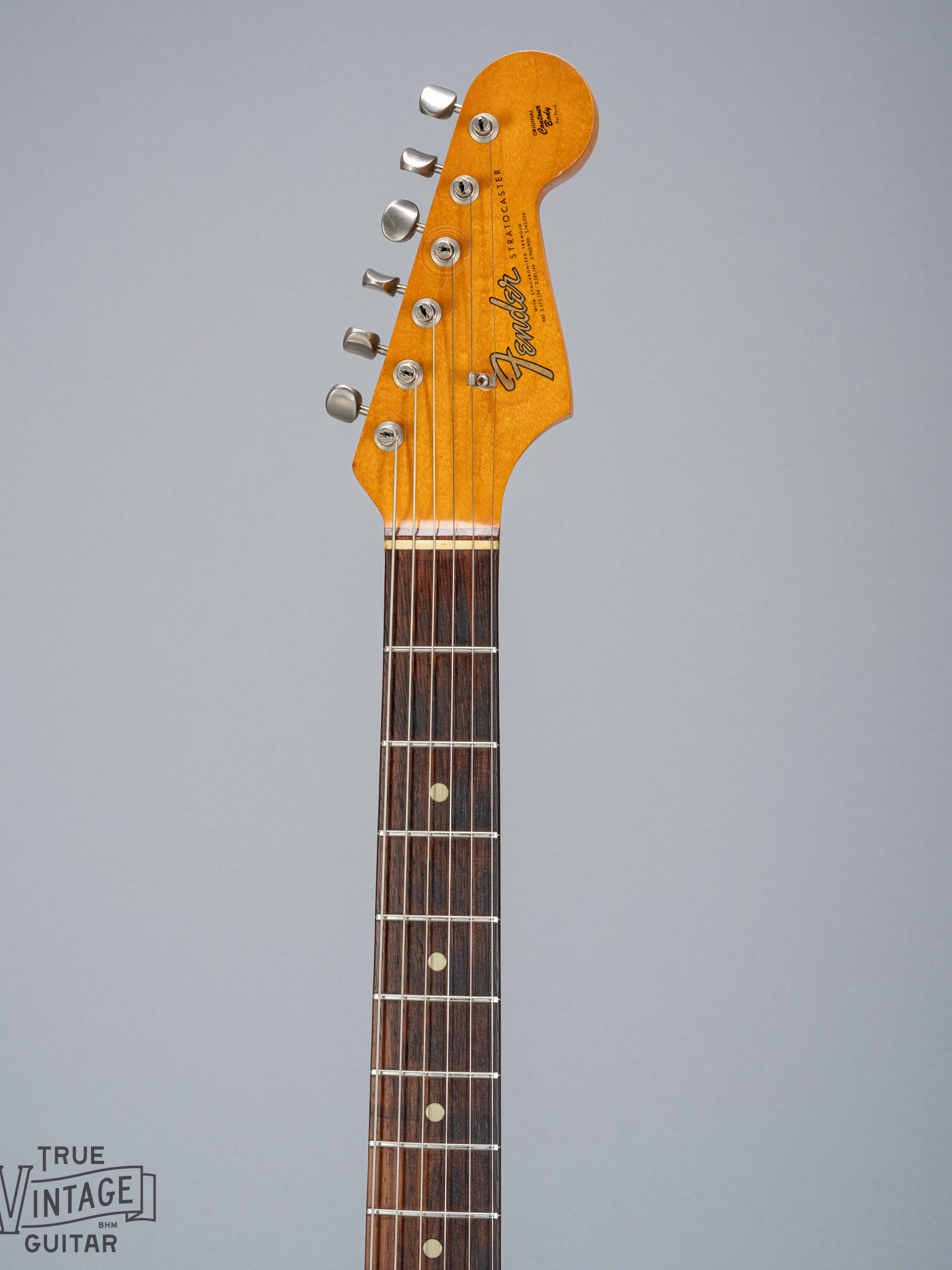front of 1965 Fender Stratocaster Sunburst guitar neck headstock and fretboard Fender logo nut tuning machines