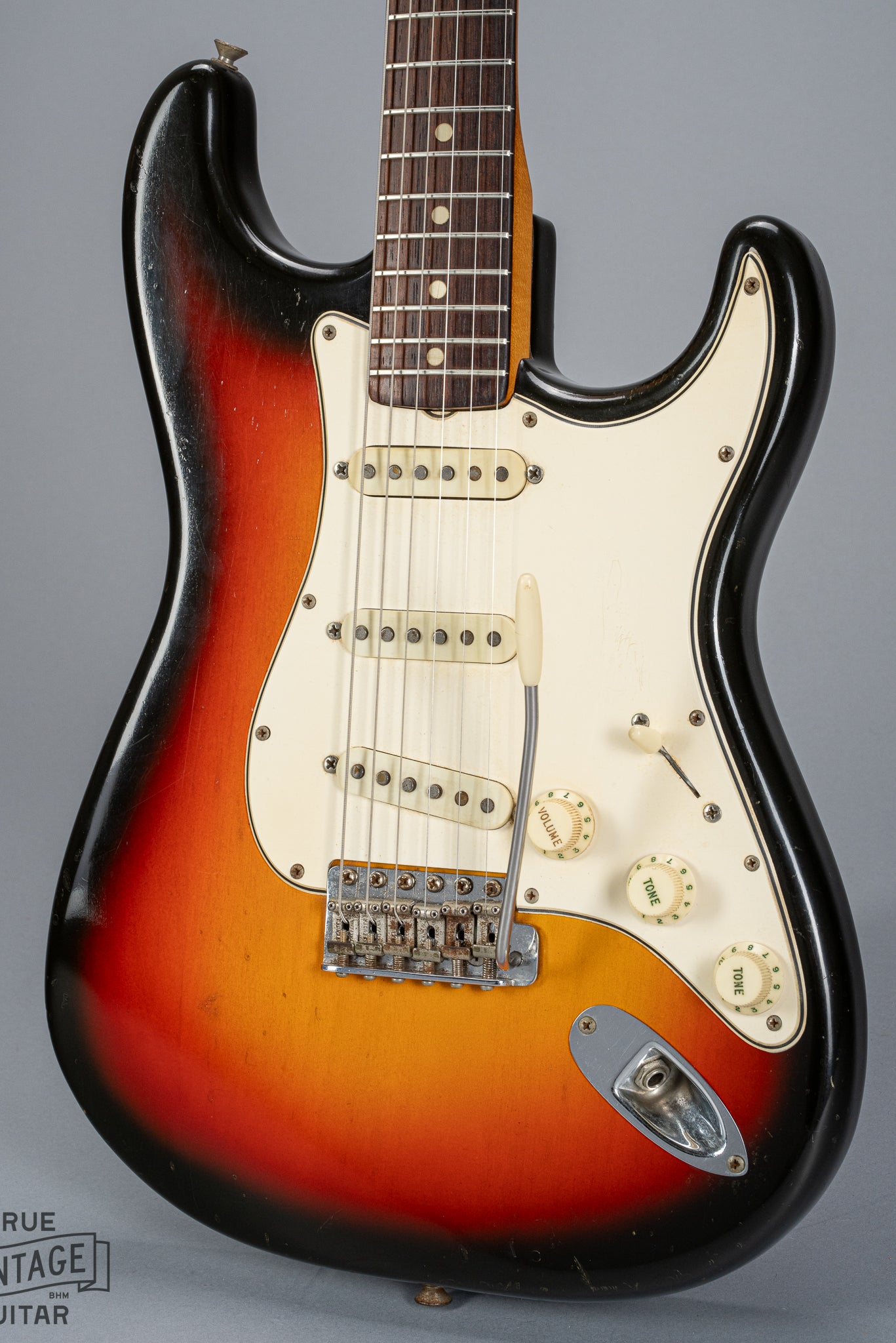 front of 1965 Fender Stratocaster Sunburst guitar body 3 ply pickguard single coil pickups volume and tone controls bridge tremolo arm