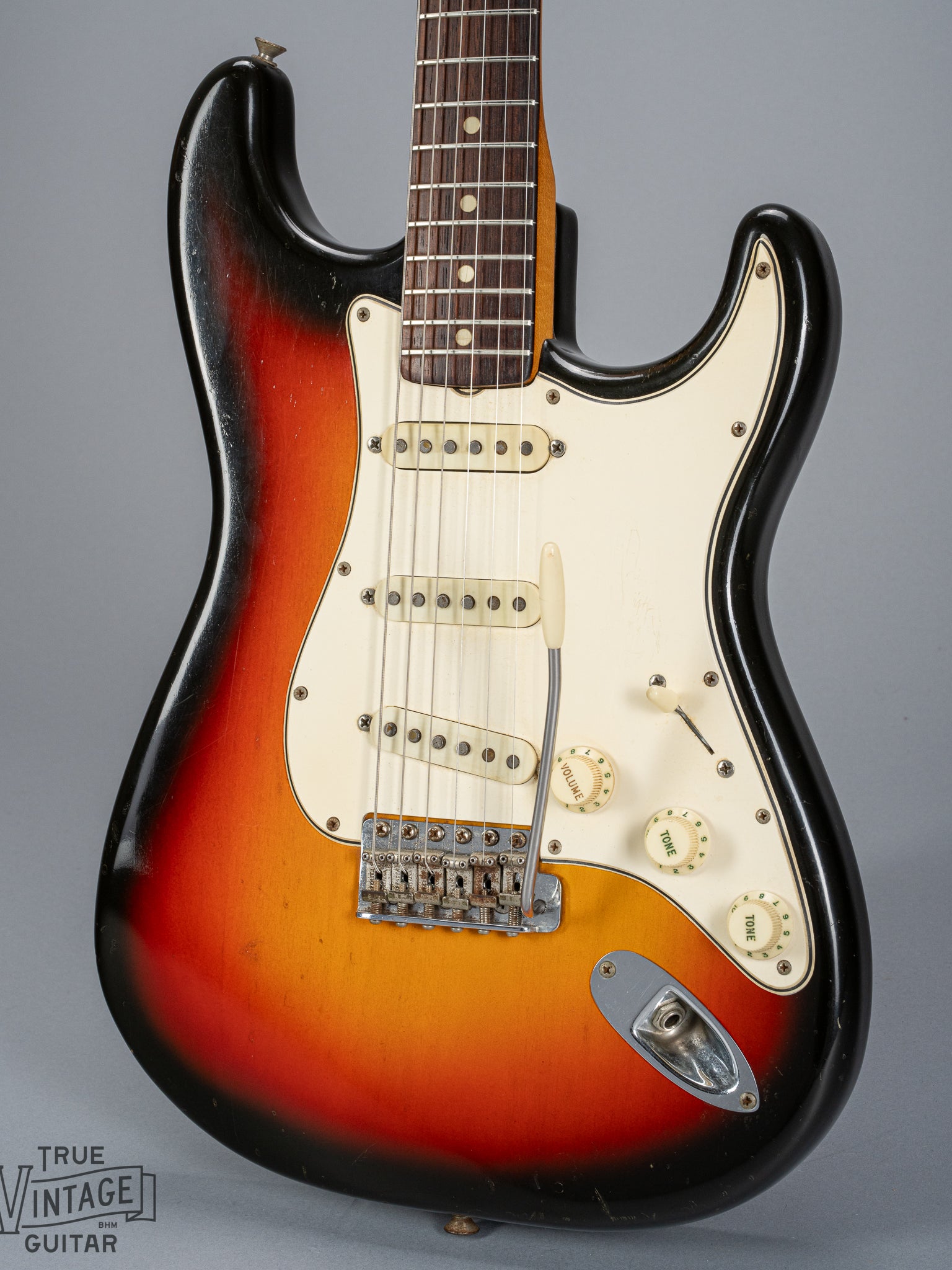 front of 1965 Fender Stratocaster Sunburst guitar body 3 ply pickguard single coil pickups volume and tone controls bridge tremolo arm