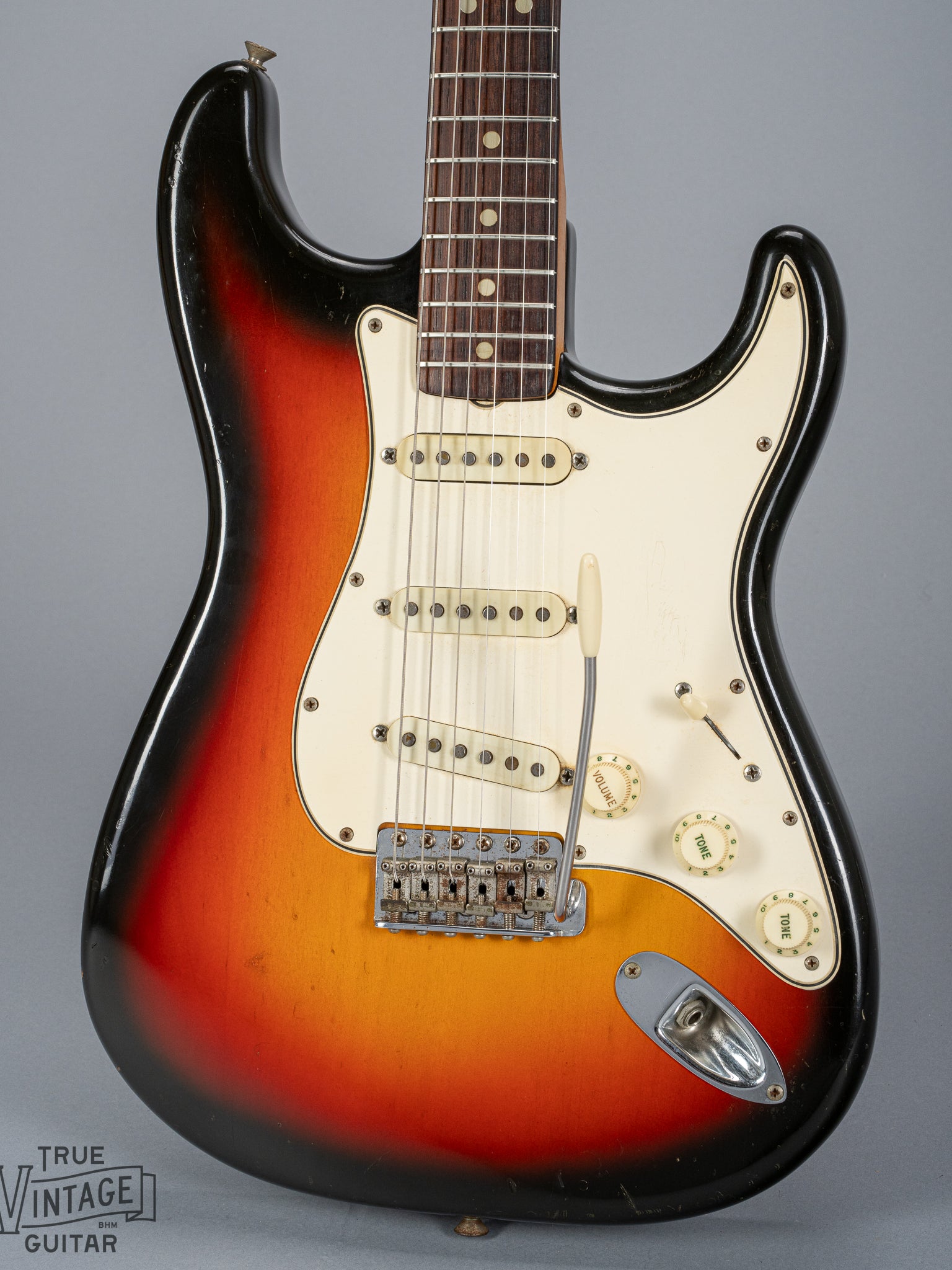 front of 1965 Fender Stratocaster Sunburst guitar body 3 ply pickguard single coil pickups volume and tone controls bridge tremolo arm