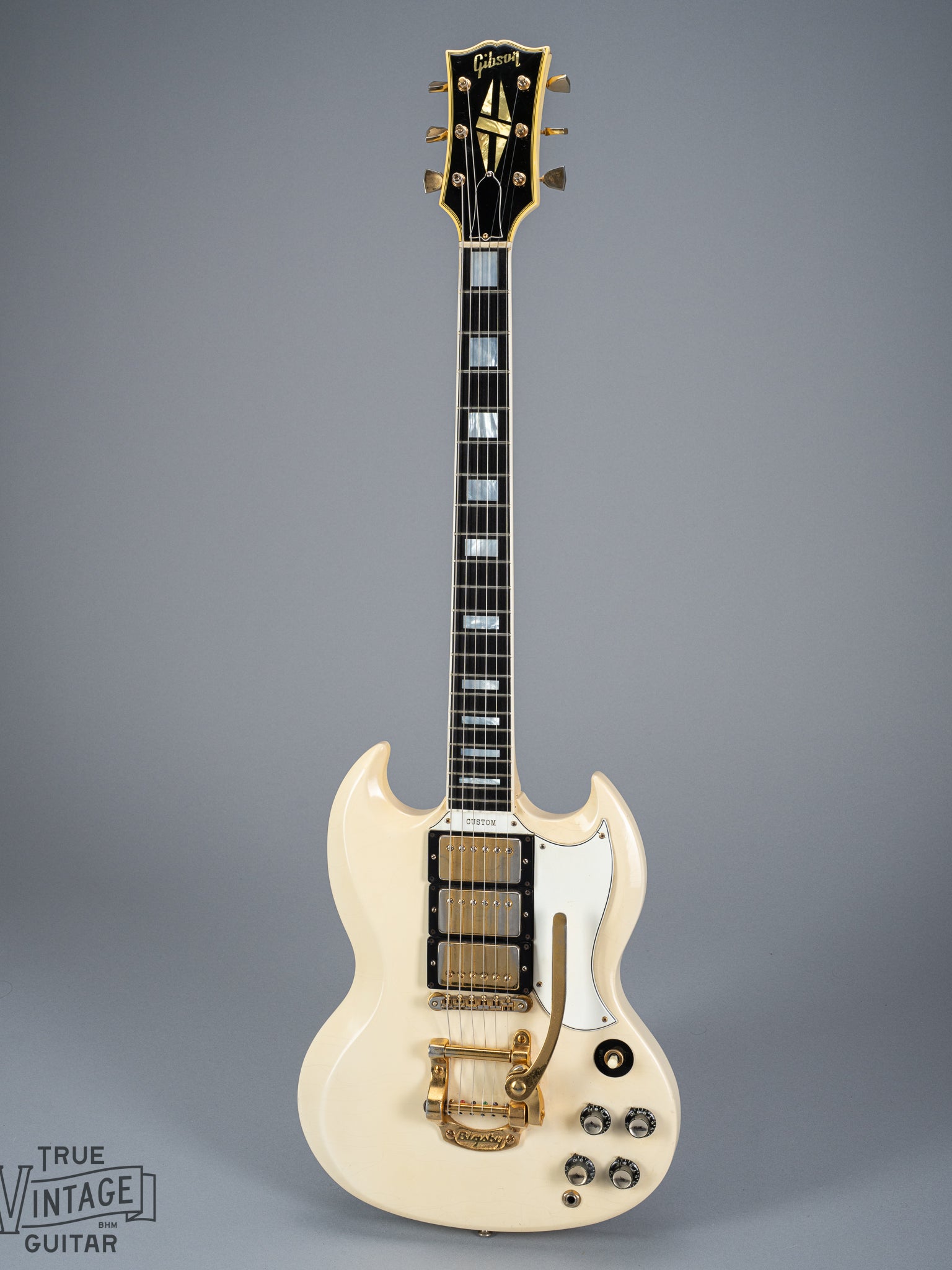 Front of 1965 Gibson SG Custom white guitar three pickup bigsby volume and tone controls block inlays fretboard binding gold neck headstock tuners block inlays