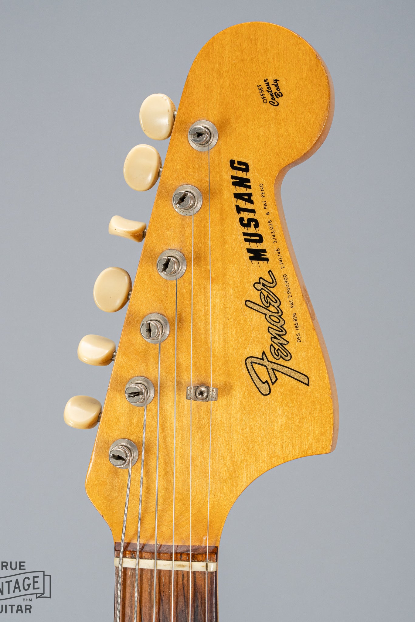 front of 1965 Fender Mustang Red guitar Headstock nut tuning machines tuning buttons original Fender logo