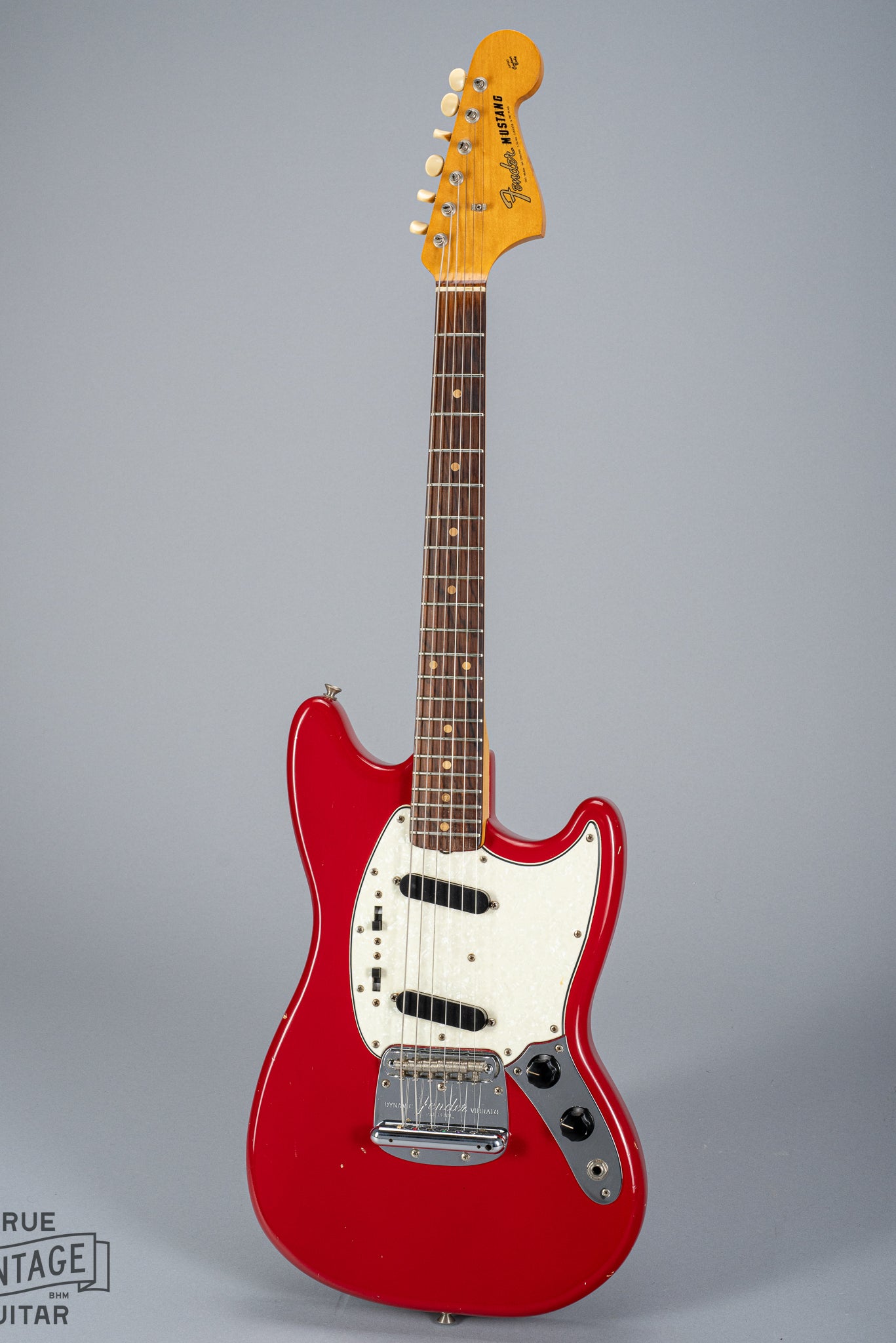 front of 1965 Fender Mustang Red guitar sparkle pick guard single coils original hardware neck fretboard headstock logo tuning buttons