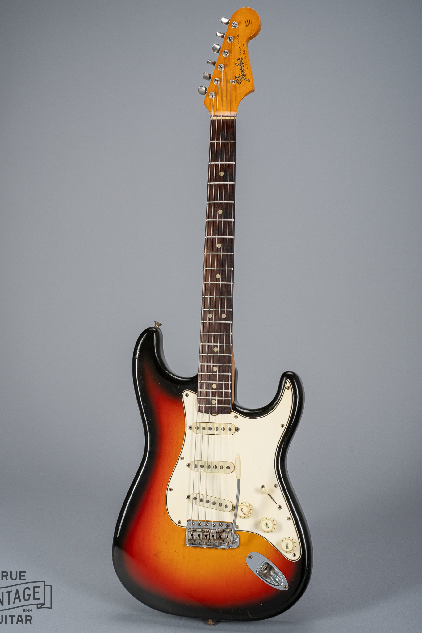 front of 1965 Fender Stratocaster Sunburst guitar body neck and headstock fretboard 3 ply pickguard single coil pickups volume and tone controls bridge tremolo arm