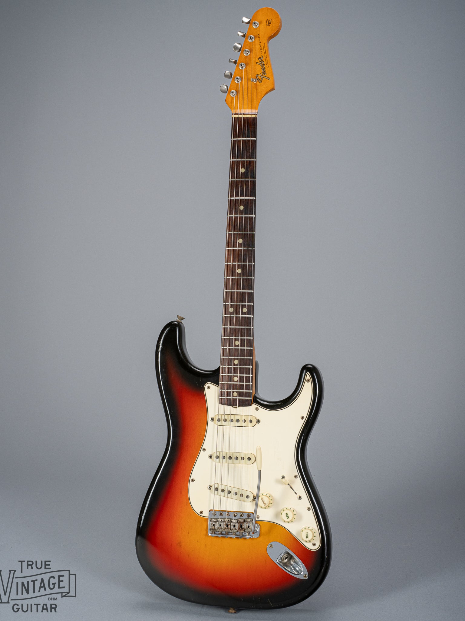 front of 1965 Fender Stratocaster Sunburst guitar body neck and headstock fretboard 3 ply pickguard single coil pickups volume and tone controls bridge tremolo arm