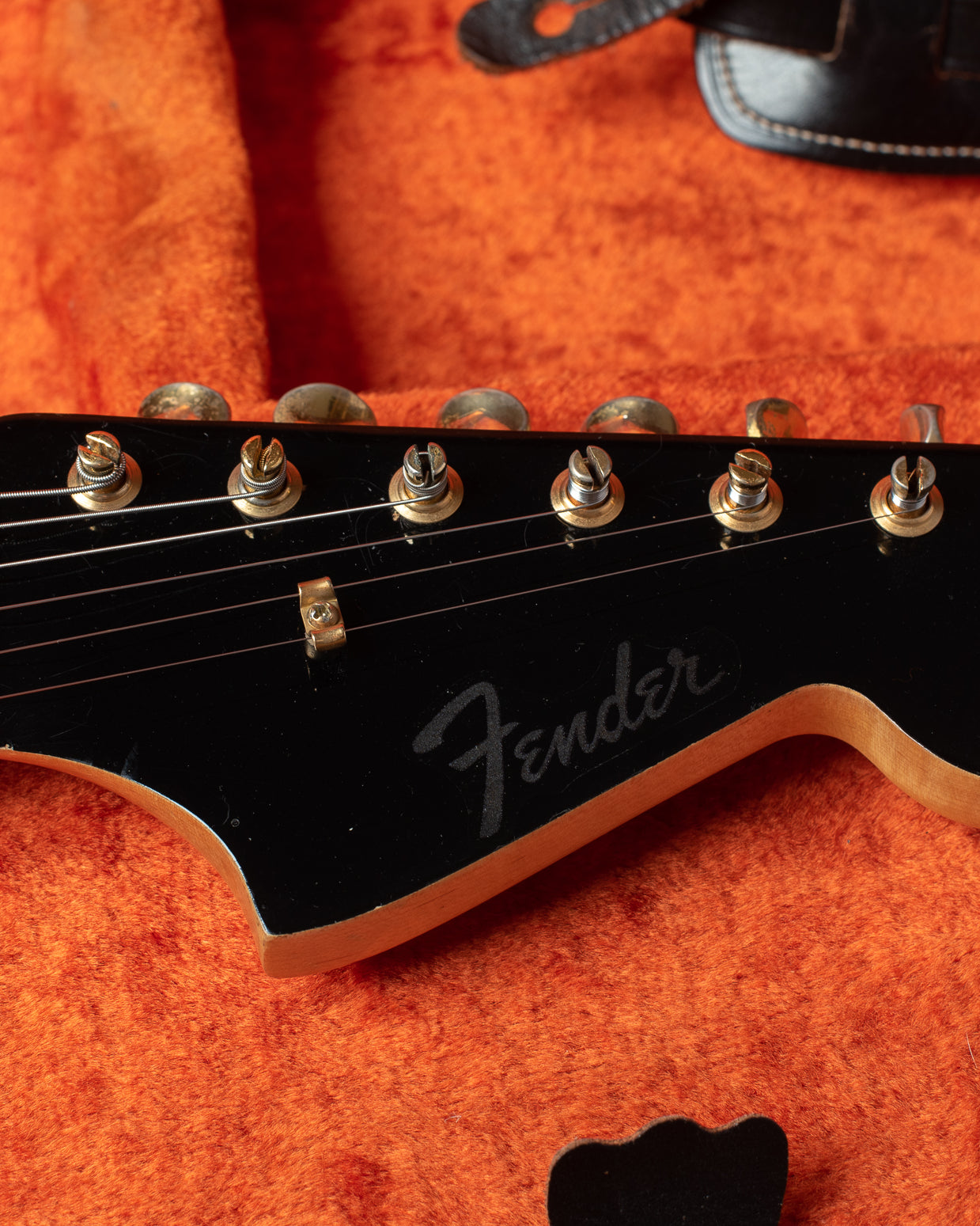 Black matching headstock with gold hardware and clipped Fender logo. No model name.