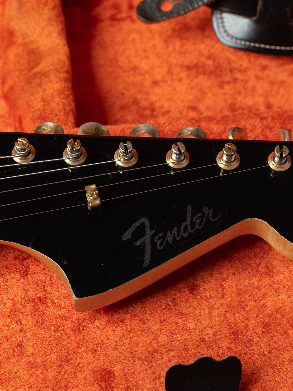 Black matching headstock with gold hardware and clipped Fender logo. No model name.