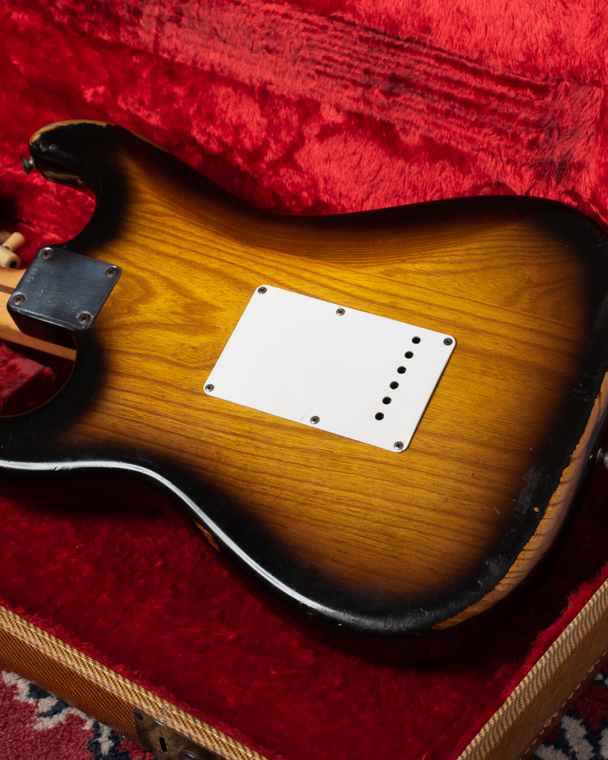 Finish wear on Ash body of 1954 Fender Stratocaster. Small holes on the tremolo cover.