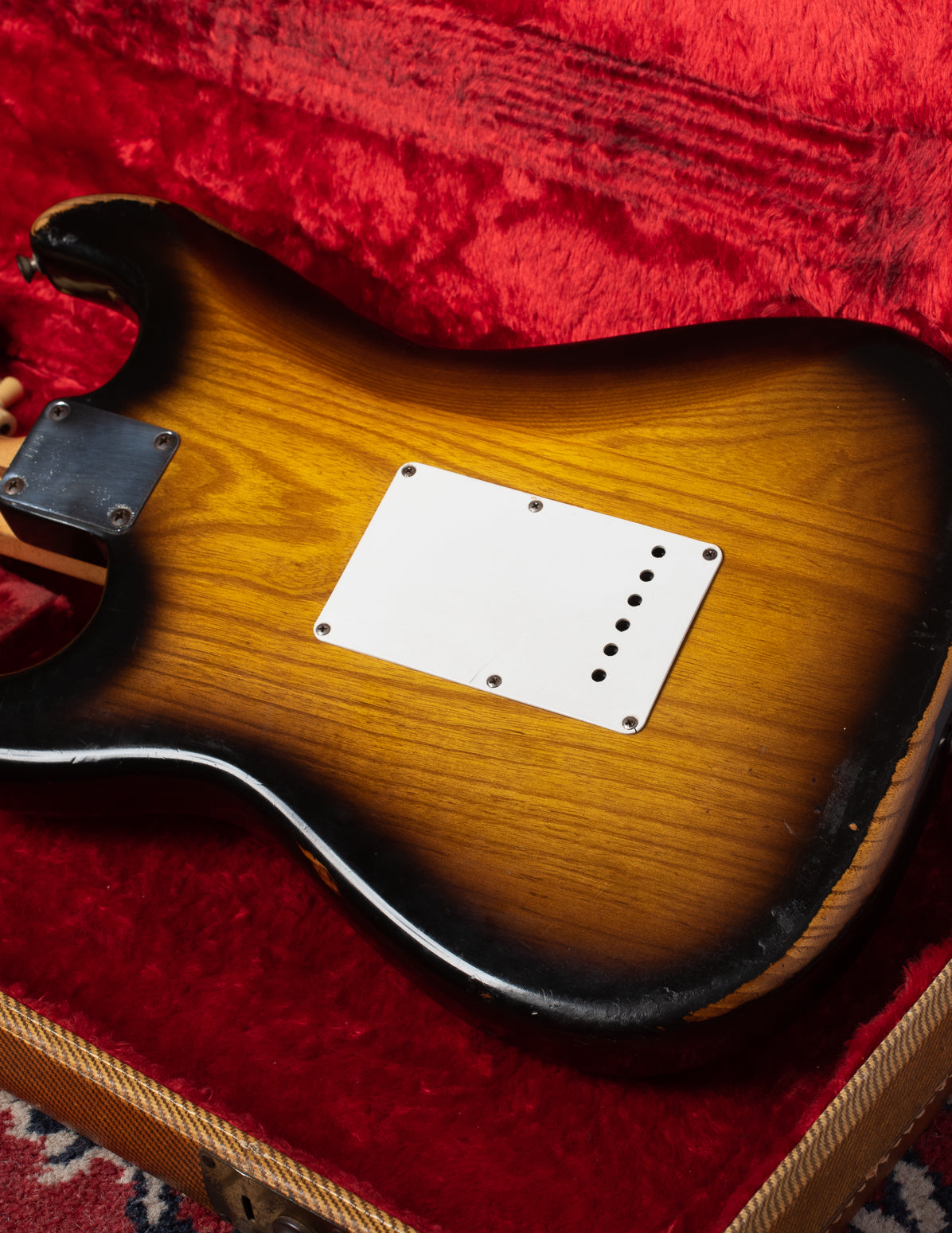 Finish wear on Ash body of 1954 Fender Stratocaster. Small holes on the tremolo cover.