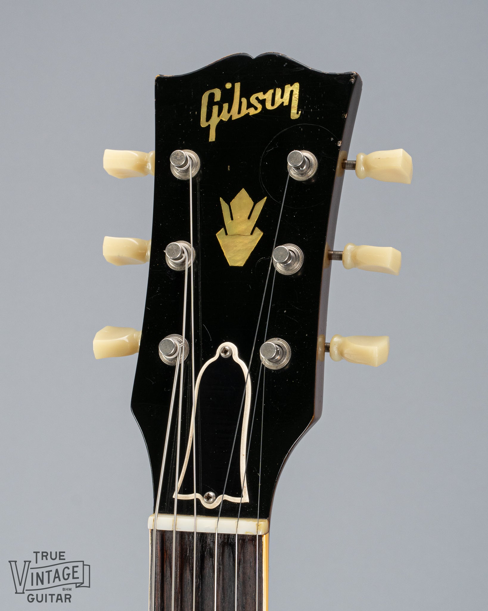 This image shows the front of the headstock of a 1959 Gibson ES-335 with pearl Gibson inlay