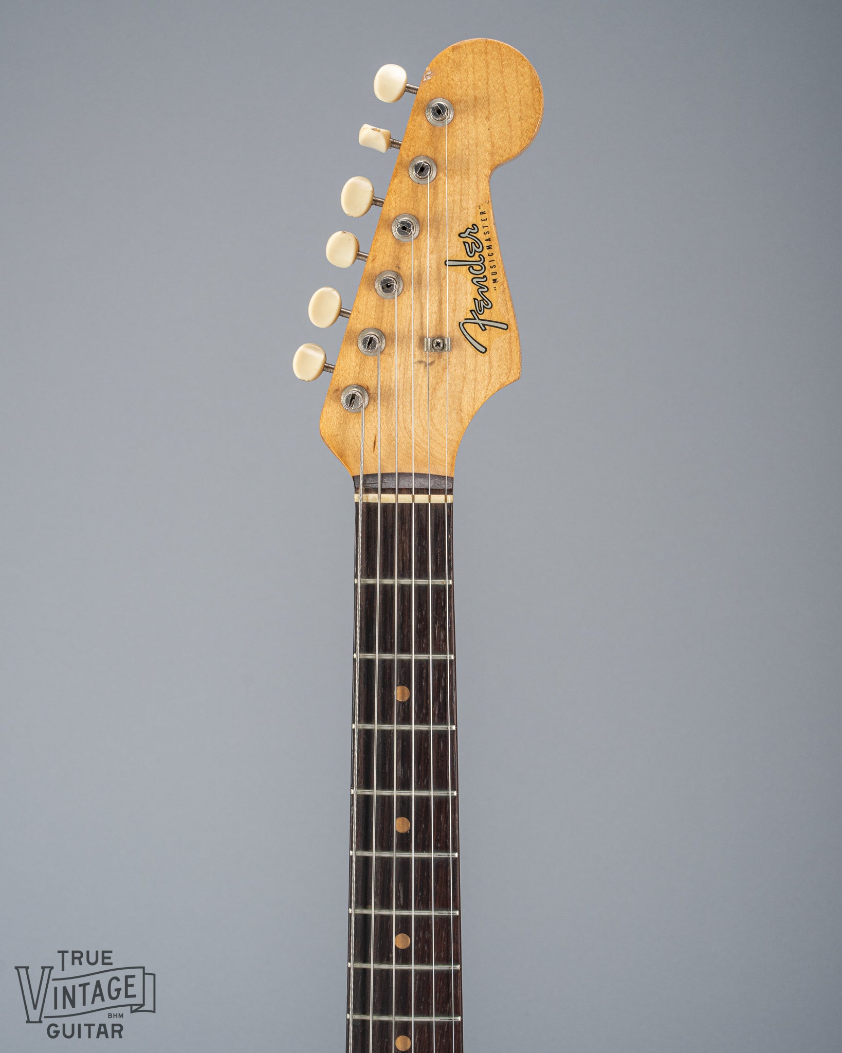 Front of 1960 Fender Musicmaster desert sand guitar neck and headstock fretboard tuners fender logo 