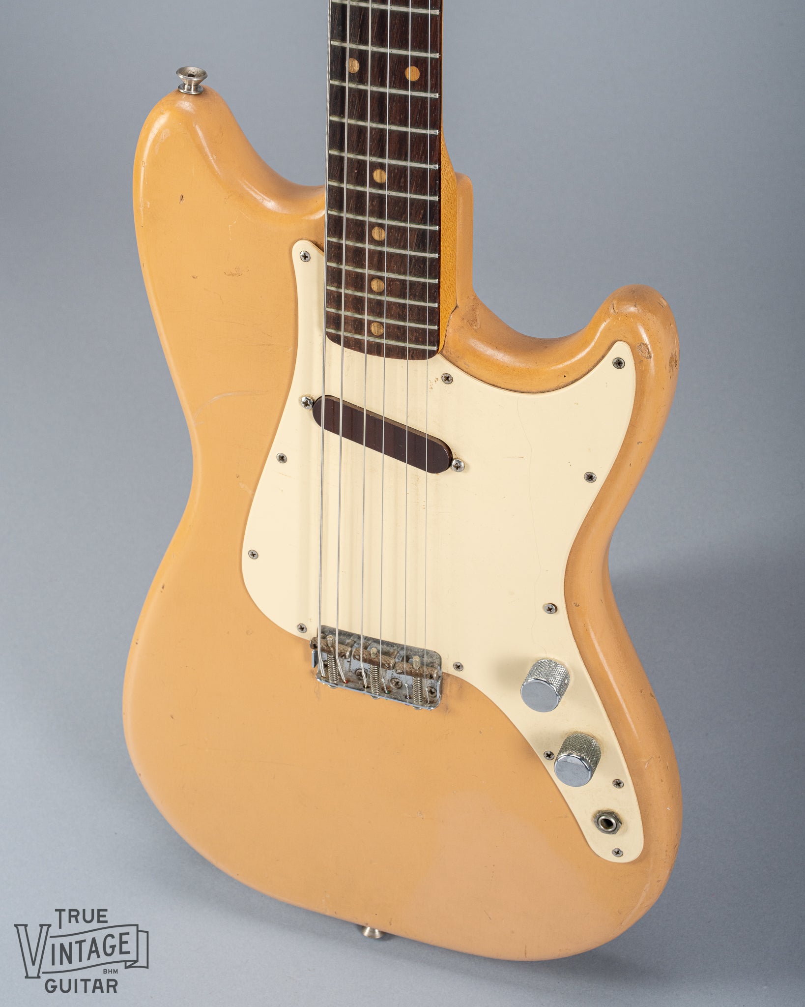 Front of 1960 Fender Musicmaster desert sand guitar body volume tone controls single coil pickups fretboard