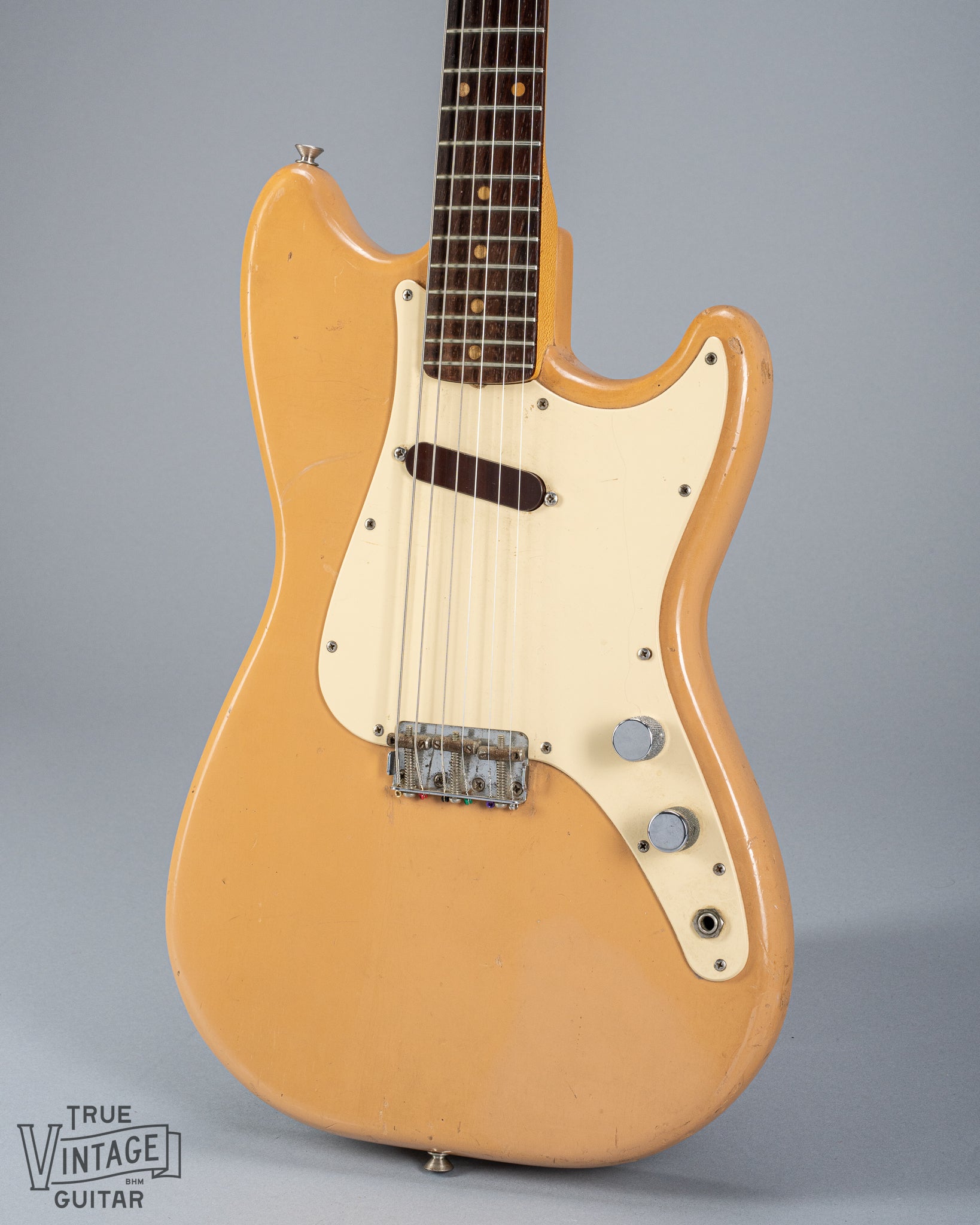 Front of 1960 Fender Musicmaster desert sand guitar body volume tone controls single coil pickups fretboard