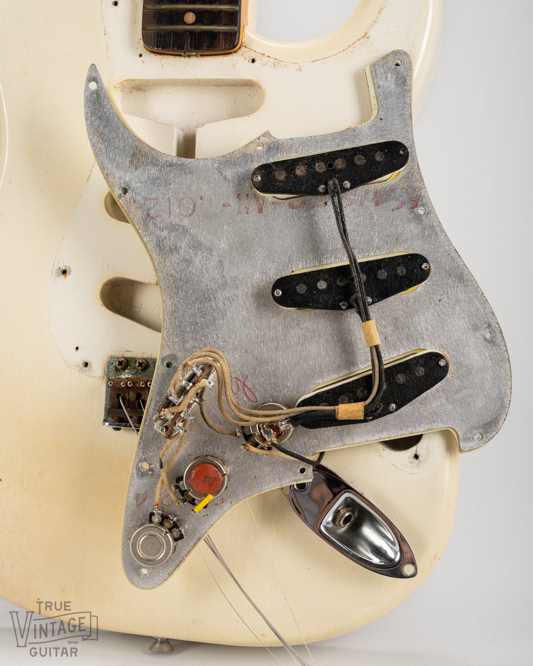 Underside of the pickguard with black bobbin pickups, potentiometers, capacitor, switch