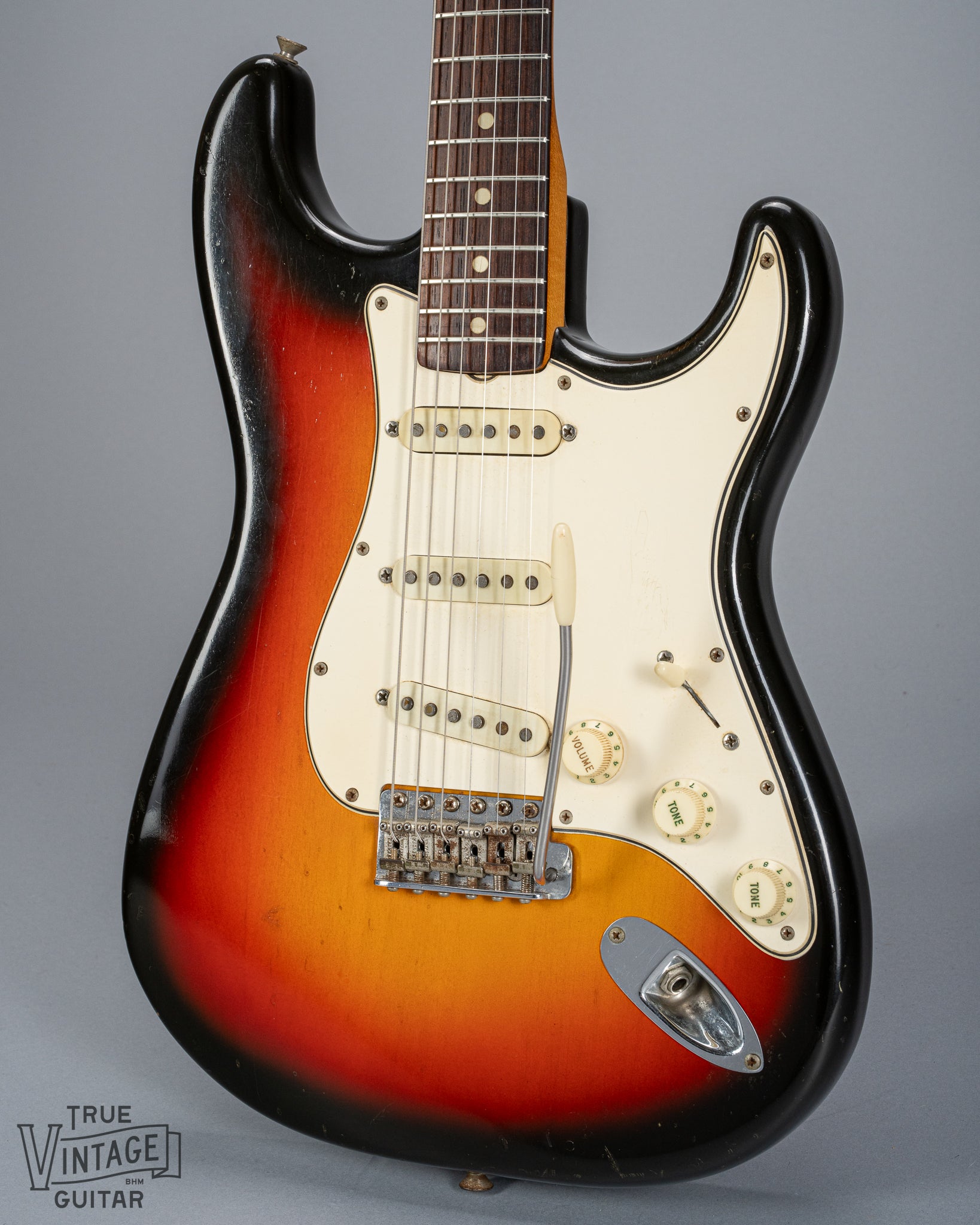 front of 1965 Fender Stratocaster Sunburst guitar body 3 ply pickguard single coil pickups volume and tone controls bridge tremolo arm