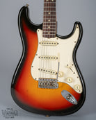 front of 1965 Fender Stratocaster Sunburst guitar body 3 ply pickguard single coil pickups volume and tone controls bridge tremolo arm