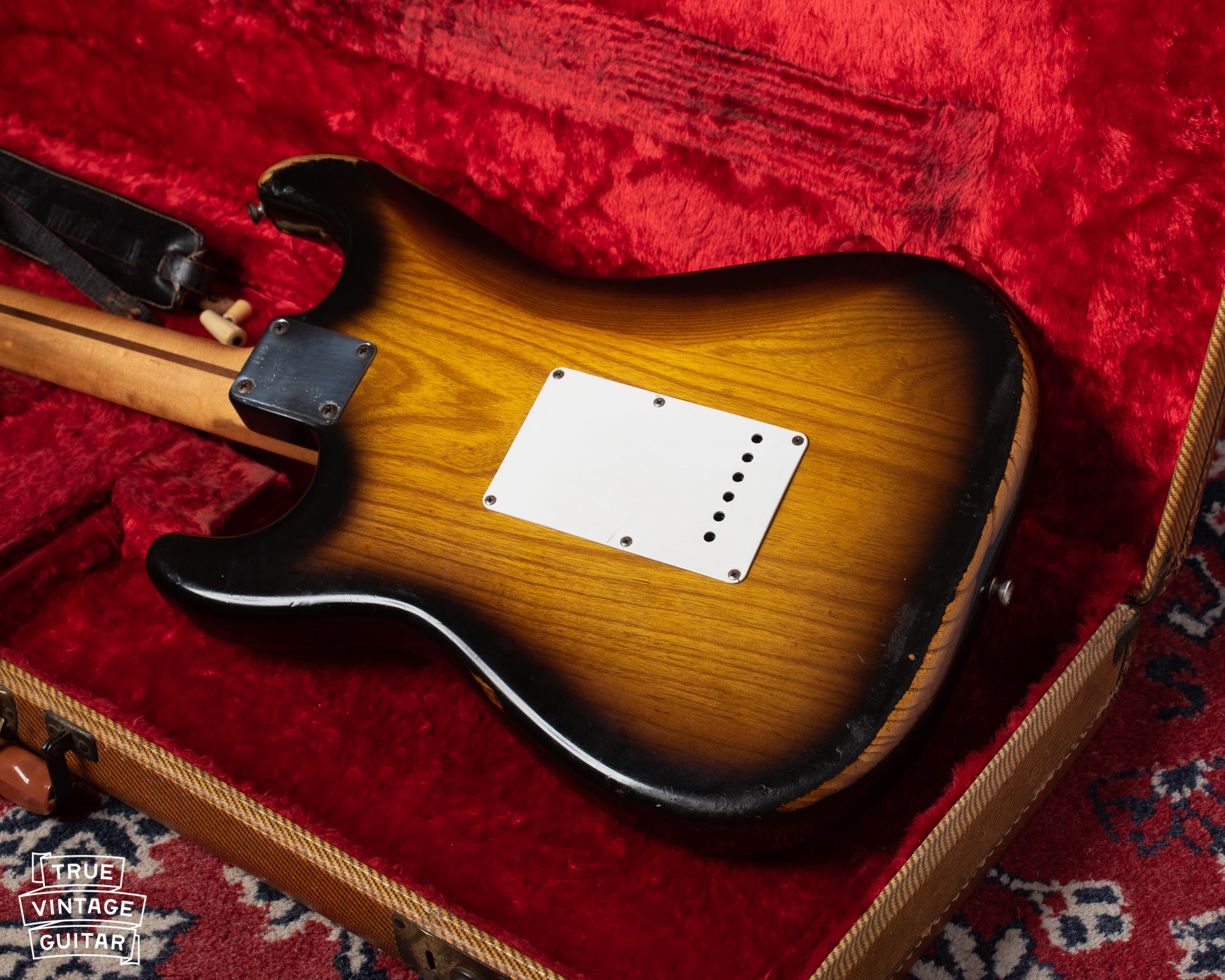 Finish wear on Ash body of 1954 Fender Stratocaster. Small holes on the tremolo cover.